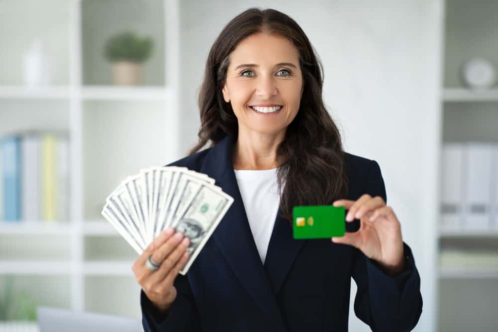 Lady holding dollars cash and credit card